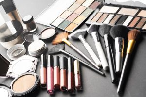 Multiple cosmetic products on black background. High resolution image for cosmetics and fashion industry.